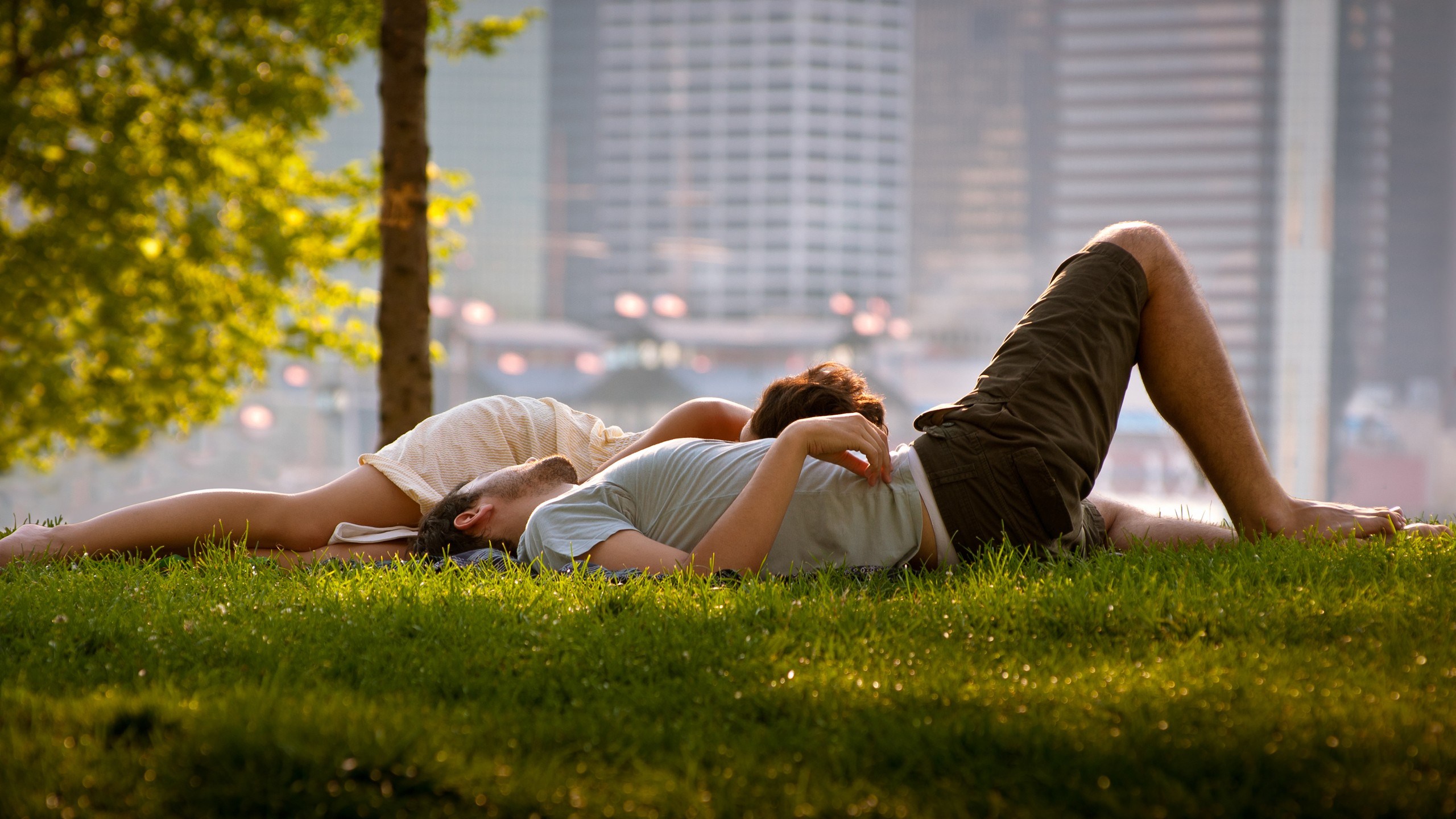 in-love-couple-sitting-on-grass-relaxing-city-park-wide-hd-wallpaper